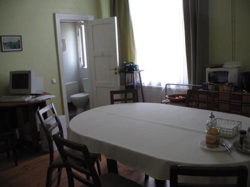 Cette chambre dispose d'une table et de chaises blanches ainsi que d'une fenêtre. dans l'établissement Kastani Home Accommodation, à Tartu