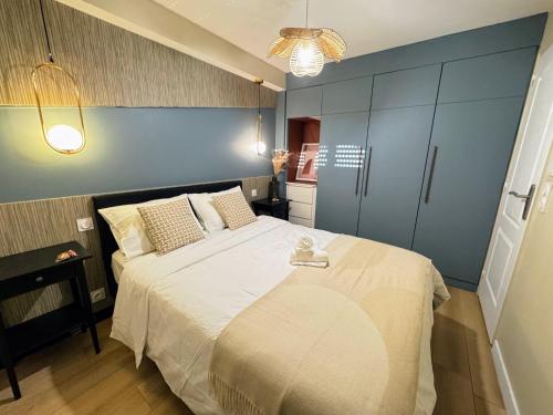 une chambre avec un grand lit avec un mur bleu dans l'établissement L'Escale - CDG - Parking - Confort, à Louvres