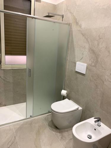 a bathroom with a shower and a toilet and a sink at Calypso Home in Torre del Greco