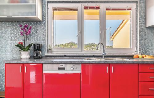 a kitchen with red cabinets and a sink at Three-Bedroom Apartment In Rogotin in Rogotin