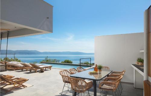 a patio with a table and chairs and a view of the ocean at Villa The View in Sveta Marina