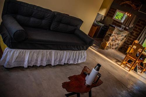 a black couch in a living room with a fireplace at Cabañas 2Tierras in Chicoana