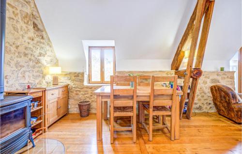 une salle à manger avec une table et des chaises en bois dans l'établissement Nice Home In Groléjac, à Groléjac