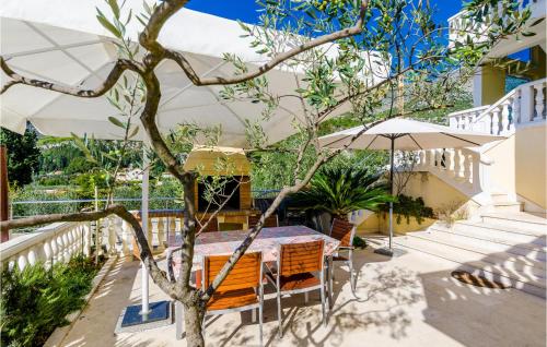 a table and chairs with an umbrella on a patio at One-Bedroom Apartment In Slano in Slano