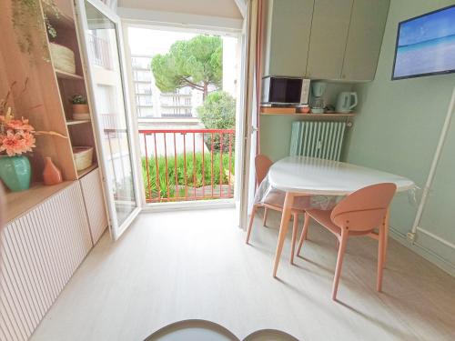 Cette petite chambre dispose d'une table, de chaises et d'un balcon. dans l'établissement Studio 50m tram parking gratuit 13min gare, à Montpellier