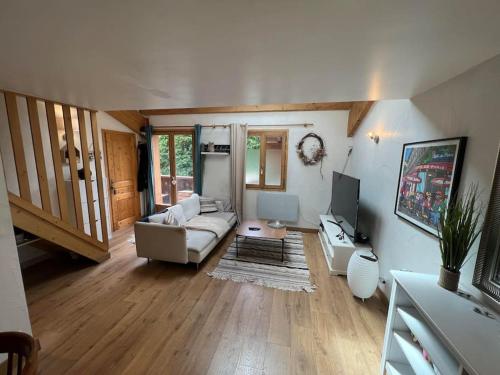 un salon avec un canapé et une télévision dans l'établissement Appartement cosy - 3 personnes, à Sainte-Foy-Tarentaise