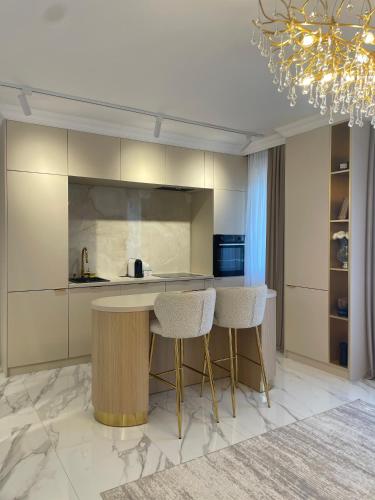 a kitchen with a table and two stools at Vanilla Studio in Timişoara