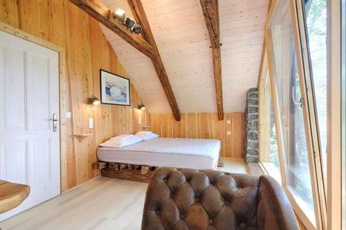 a bedroom with a bed in a wooden cabin at Forest eco-house & spa in Dolenja Ravan