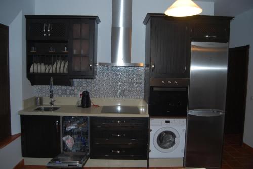 a kitchen with a washing machine and a washer at Apartamentos Bodeguetas in Constantina