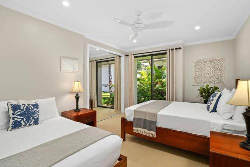 a bedroom with two beds and a window at Chic Princeville Villa Private Pool Relaxation and AC in Princeville
