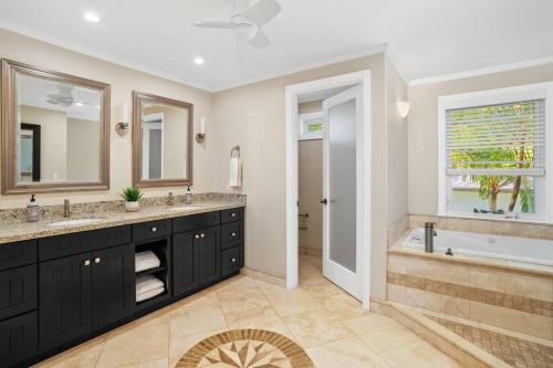 a bathroom with two sinks and a tub and a shower at Chic Princeville Villa Private Pool Relaxation and AC in Princeville