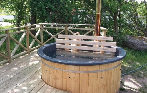 a wooden deck with a hot tub with a bench at 3 Bedroom Nice Home In Fjälkinge in Ivö