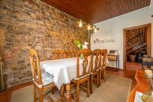 a dining room with a stone wall and a table and chairs at Casa Rural Casa Selmo in Carreno