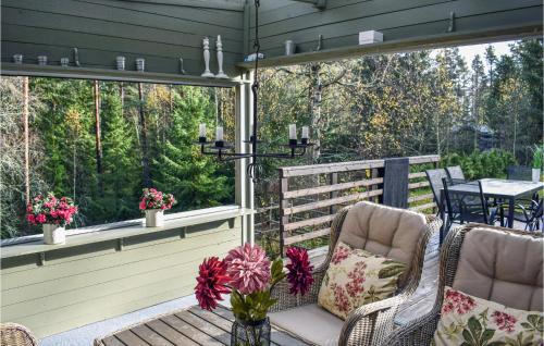 a screened in porch with two chairs and a table at Gorgeous Home In Tidaholm With Kitchen in Tidaholm
