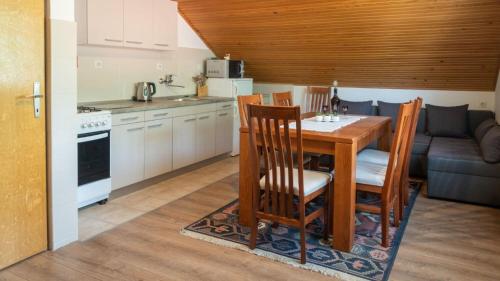 a kitchen and dining room with a table and chairs at Apartments Dar in Lokve