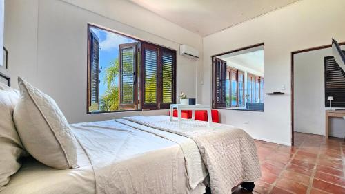 1 dormitorio con 1 cama con mesa y 2 ventanas en LoveShack Villa in Shacks Beach, Isabela, en Isabela