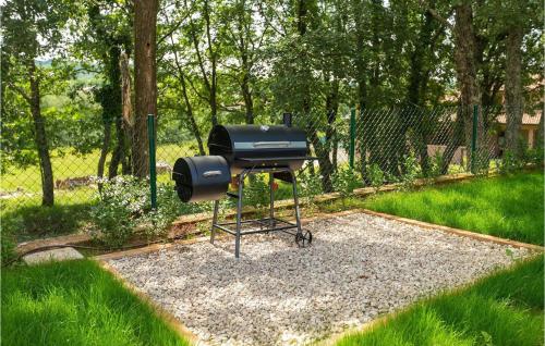 a barbecue grill sitting on gravel in a yard at Villa Brih Iii in Motovun