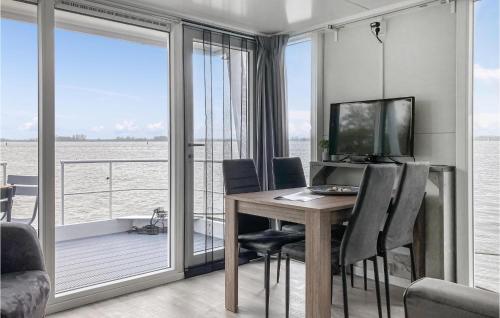 a dining room with a table with chairs and a television at Stunning Ship In Biddinghuizen in Biddinghuizen