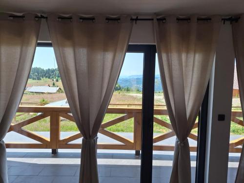 a room with curtains and a large window with a view at Planinska kuća Vesna in Sekulić 