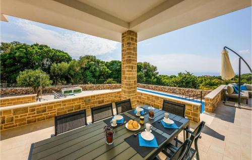 a patio with a table and chairs and a pool at Pet Friendly Home In Lun in Lun