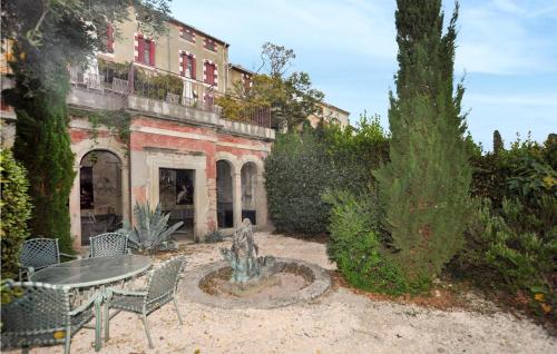 un jardin avec une table et une fontaine en face d'un bâtiment dans l'établissement Nice Home In Ventenac-En-Minervois, à Ventenac en Minervois