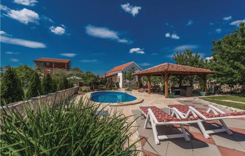 un patio avec deux chaises et un gazebo et une piscine dans l'établissement Two-Bedroom Holiday Home In Zemunic Gornji, à Vlašnović