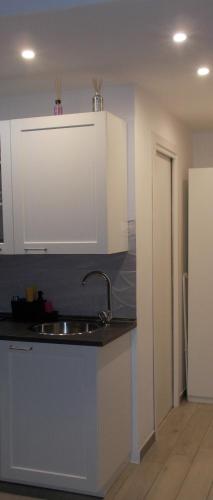 a kitchen with a sink and white cabinets at Akihome Portanova in Naples