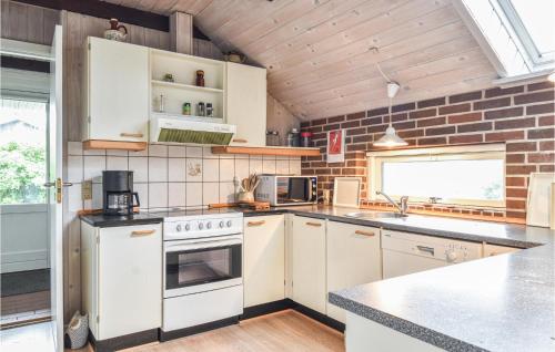 a kitchen with white appliances and a brick wall at Holiday Home P Snejkers Vej Ringkøbing I in Søndervig