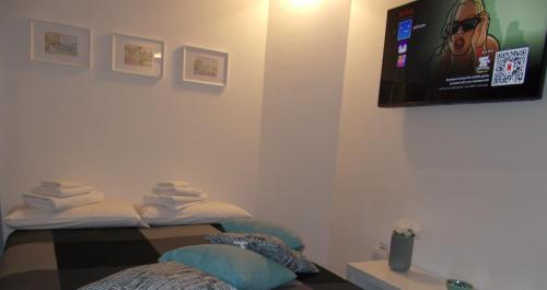 a room with two beds and a tv on the wall at Akihome Portanova in Naples