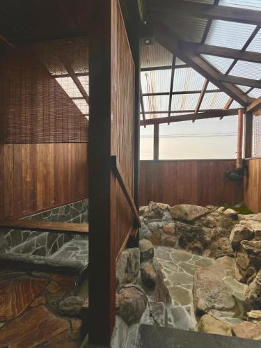 a room filled with rocks and a wooden ceiling at 湯布院我楽珍民泊Yufuin Garakuchin in Yufuin