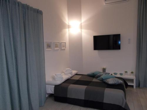a bedroom with a bed and a television on the wall at Akihome Portanova in Naples