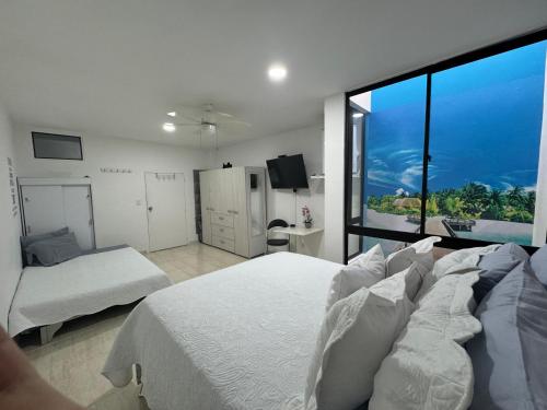 a bedroom with two beds and a large window at Modern apartment/Studio in Pereira