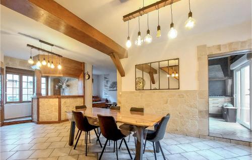 une cuisine et une salle à manger avec une table et des chaises en bois dans l'établissement Stunning Home In Grand-Fort-Philippe, à Grand-Fort-Philippe