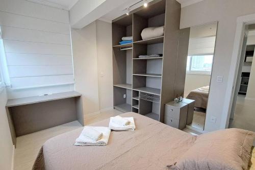 a bedroom with a bed with towels on it at Apartamento aconchegante próximo Maria Fumaça in Bento Gonçalves