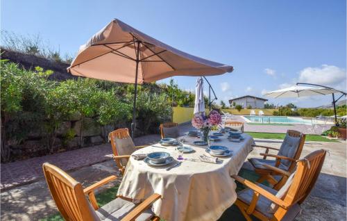 a table and chairs with an umbrella and a pool at Cozy Home In Caccamo With Kitchenette in Caccamo