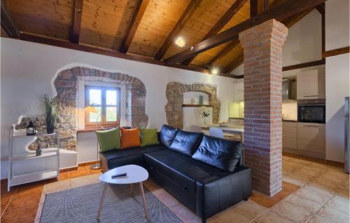 a living room with a black couch and a kitchen at Villa Casa Mira in Vižinada