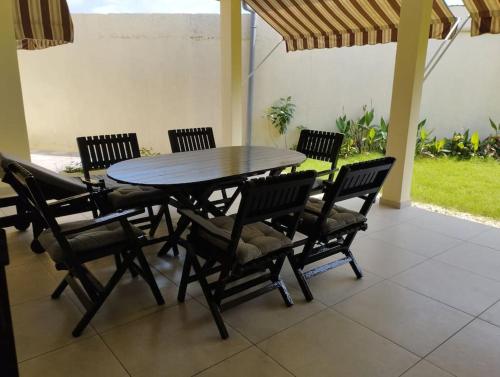a table and chairs in a room with a patio at Charmante maison Riviera Golf Jardins in Abidjan