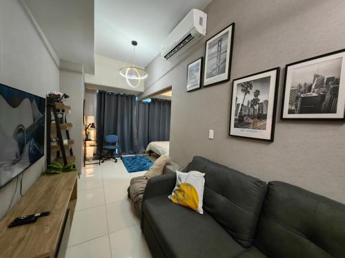 a living room with a couch and a bedroom at Cozy 1BR with Balcony and Netflix in Uptown BGC in Manila