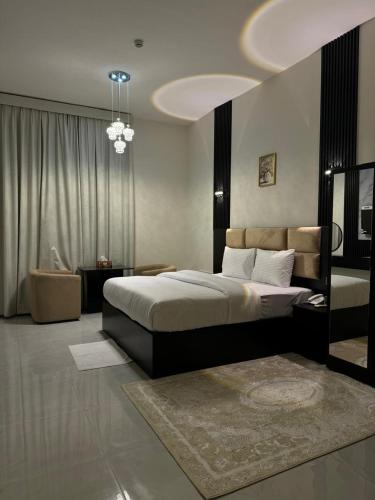 a bedroom with a large bed and a living room at Al Zahra Hotel Apartments Ras Al Khaimah in Ras al Khaimah