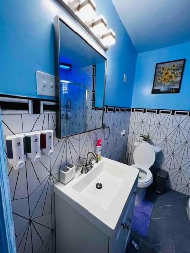 a blue bathroom with a sink and a toilet at Home besides Niagara Falls, NY in Niagara Falls