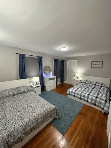 a bedroom with two beds and a wooden floor at Home besides Niagara Falls, NY in Niagara Falls