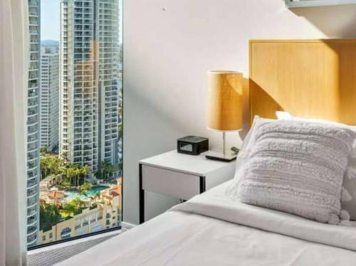 a bedroom with a bed with a view of a city at Hilton Surfers Paradise Luxury Suite - 2Bedroom, Free Car Park in Gold Coast