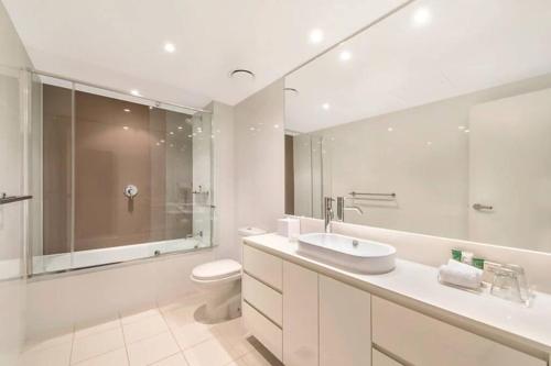 une salle de bain blanche avec un lavabo et des toilettes dans l'établissement Paradise City Lights - Privately Managed Luxury Suite on Hilton Surfers Paradise Free Carpark, à Gold Coast