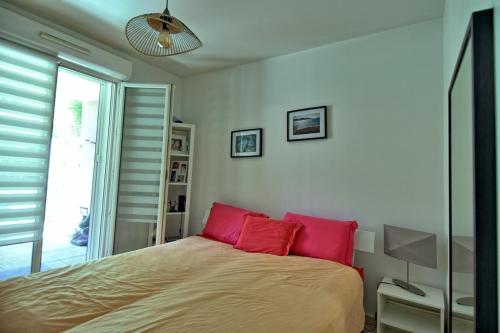 une chambre avec un lit avec deux oreillers rouges dans l'établissement Marina les calanques, à Marseille