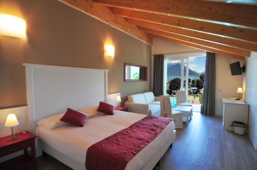 a bedroom with a large bed and a living room at Hotel Resort Le Vele in Domaso
