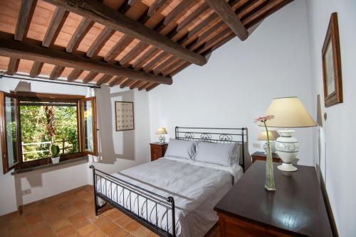 1 dormitorio con cama, mesa y ventana en Agriturismo Olmo Bello, en Capodimonte