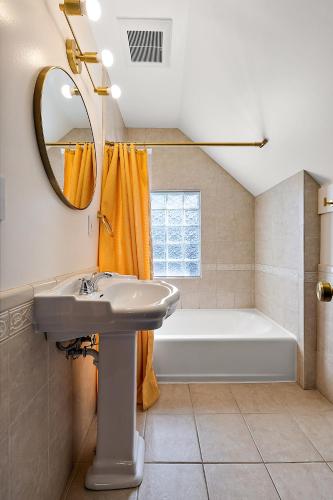 a bathroom with a sink and a tub and a mirror at The Little Big House - Home in Downtown Ann Arbor in Ann Arbor
