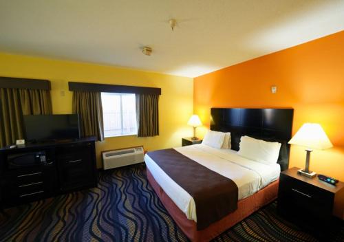 a hotel room with a large bed and a television at Rock Island Inn & Suites Streator , IL in Delbert Egan Housing Project