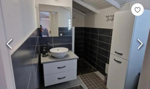 łazienka z umywalką i lustrem w obiekcie VILLA LAURAYM w mieście Baie-Mahault