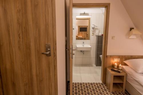 a bathroom with a door open to a bathroom with a sink at Borowy Dwór- Biznes, Spa & Fun in Szaflary